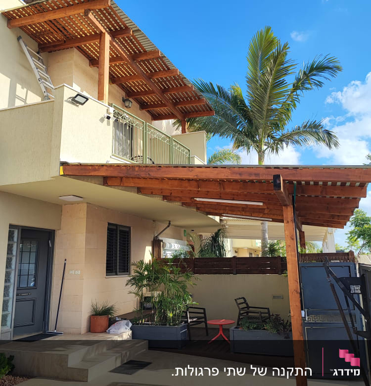 מרפסת עם פרגולה מעץ וצמחי גינה בעציצים.